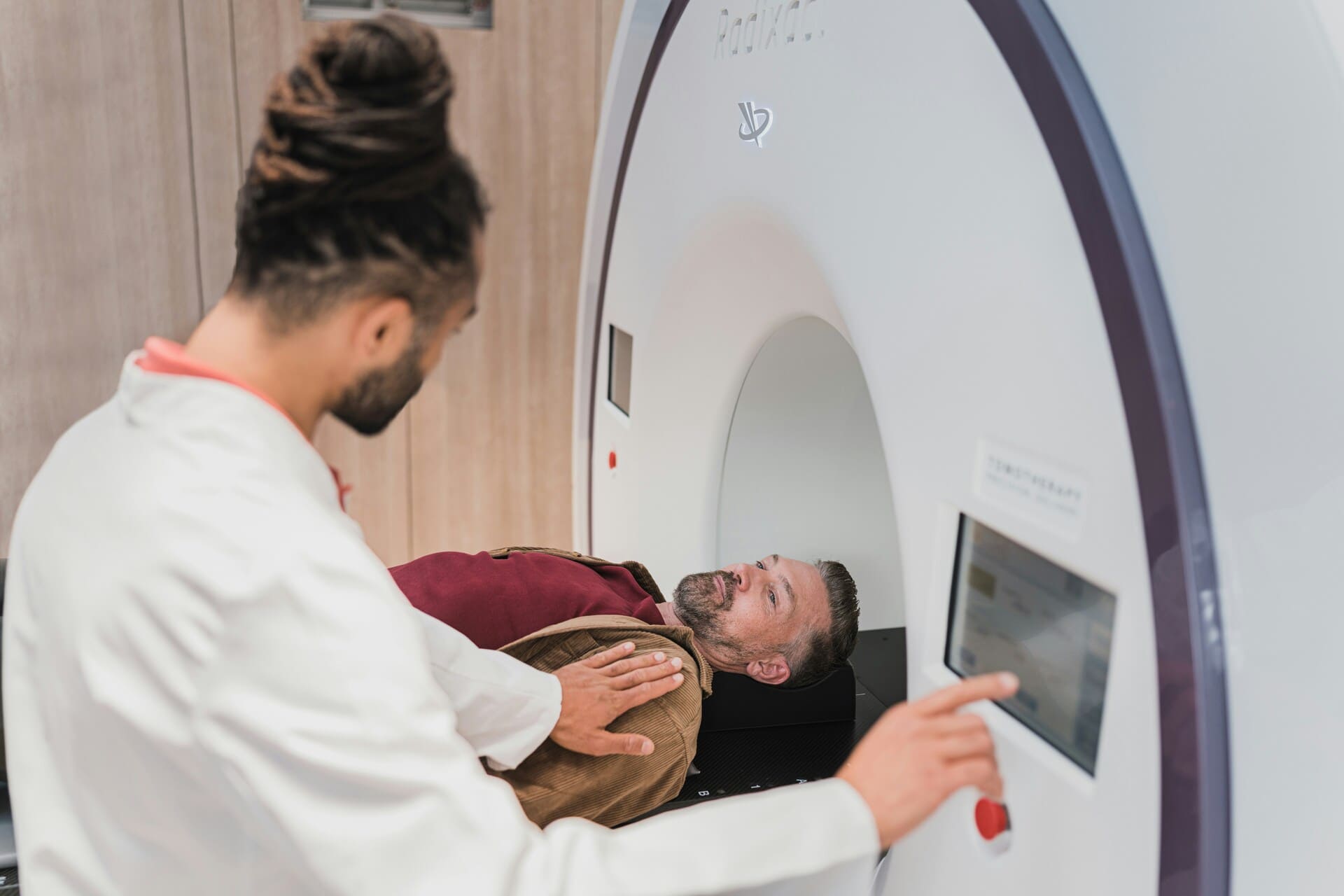 Ein Technologe stellt sicher, dass der Patient vor dem Start des CT-Scans gut informiert und positioniert ist